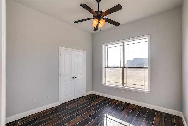 spare room with ceiling fan, baseboards, and wood finish floors