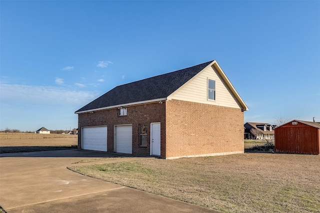 garage with a storage shed and concrete driveway