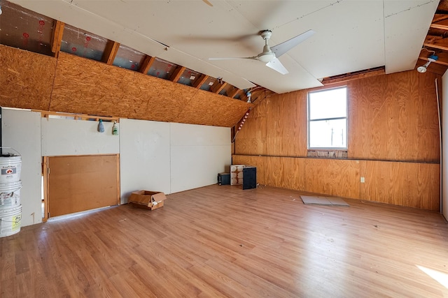 bonus room with ceiling fan, lofted ceiling, wood walls, and wood finished floors