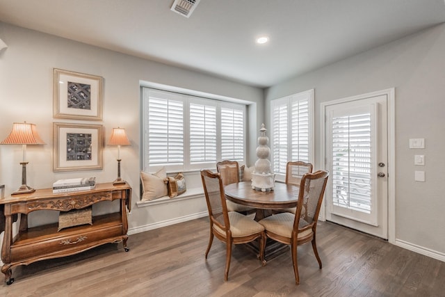 dining room featuring visible vents, baseboards, and wood finished floors