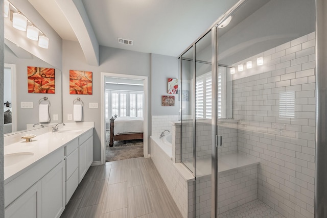 ensuite bathroom with double vanity, a stall shower, visible vents, connected bathroom, and a sink