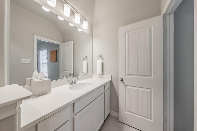 bathroom with vaulted ceiling and vanity