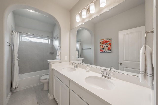 bathroom featuring shower / bathtub combination with curtain, a sink, toilet, and tile patterned floors