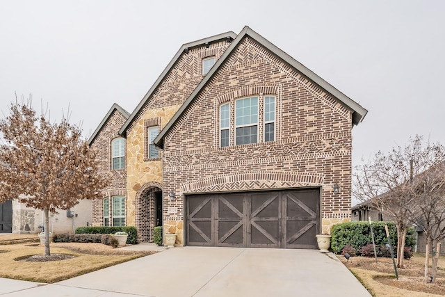 view of front facade featuring stone siding, concrete driveway, brick siding, and a garage