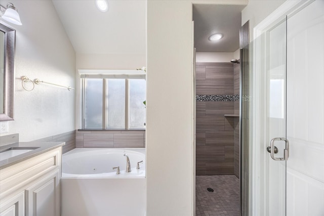 bathroom featuring a shower stall, a bath, and vanity