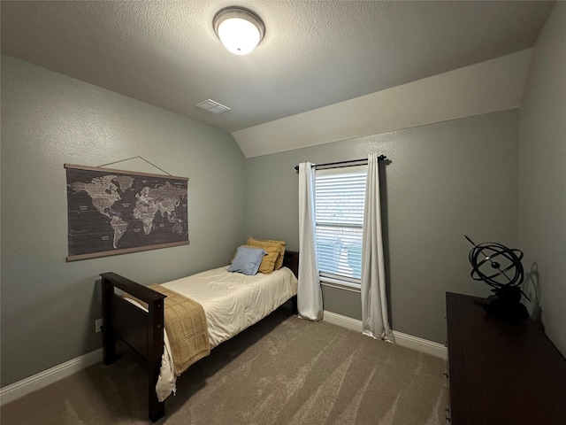 bedroom with lofted ceiling, visible vents, dark carpet, and baseboards