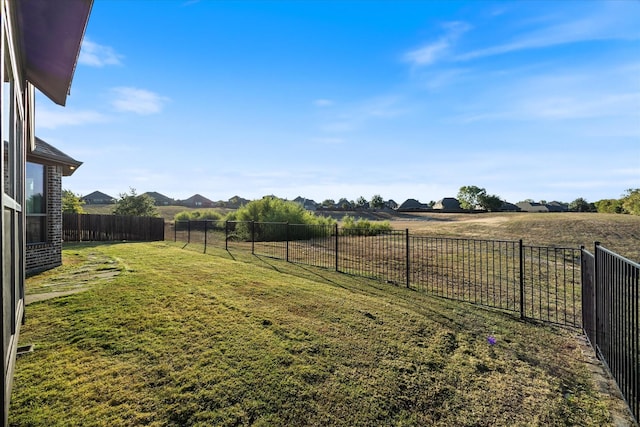 view of yard with a rural view and a fenced backyard