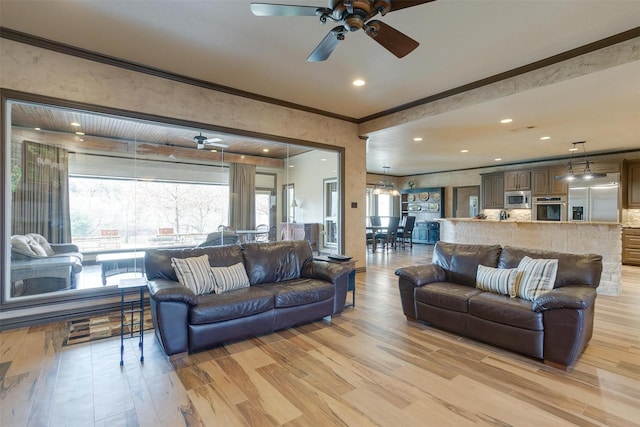 living area featuring light wood finished floors, recessed lighting, a ceiling fan, and crown molding