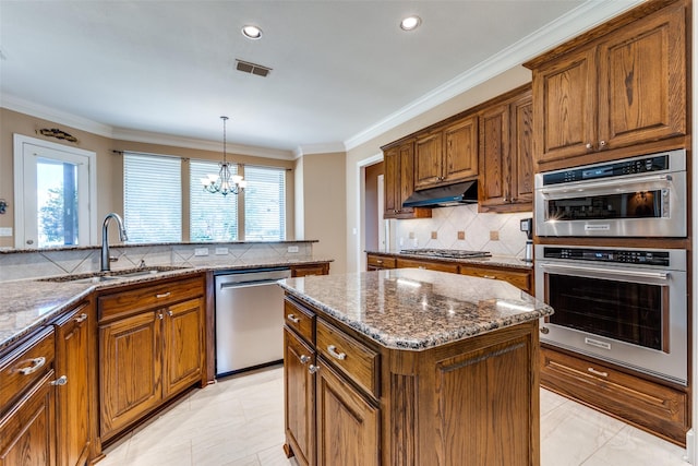 kitchen featuring visible vents, appliances with stainless steel finishes, crown molding, under cabinet range hood, and a sink