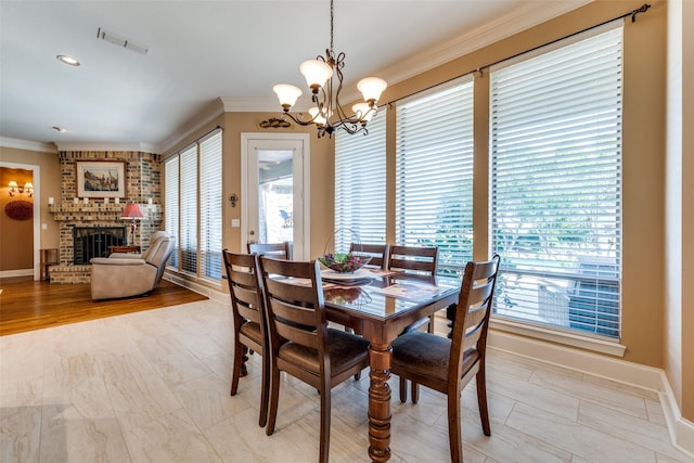 dining room featuring ornamental molding, a fireplace, visible vents, and a healthy amount of sunlight