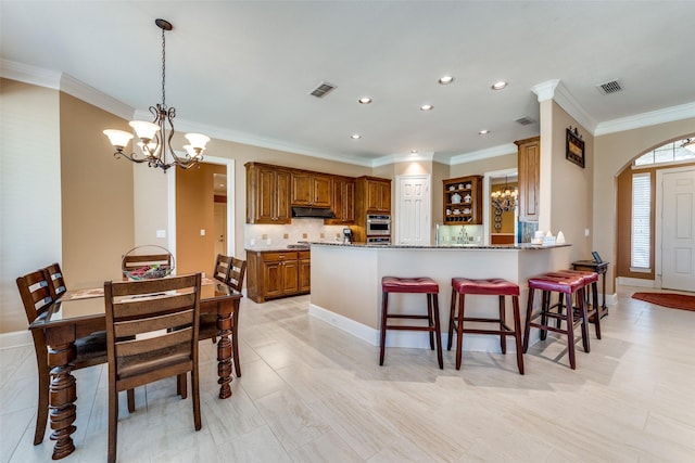 dining area with crown molding, visible vents, a notable chandelier, and baseboards