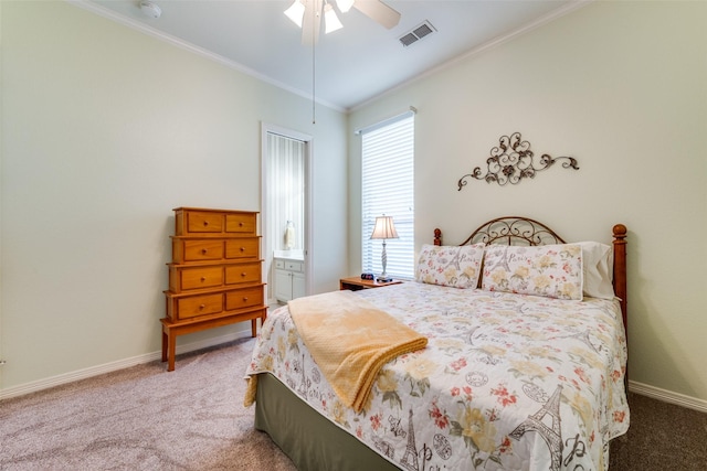 carpeted bedroom featuring crown molding, ceiling fan, visible vents, and baseboards