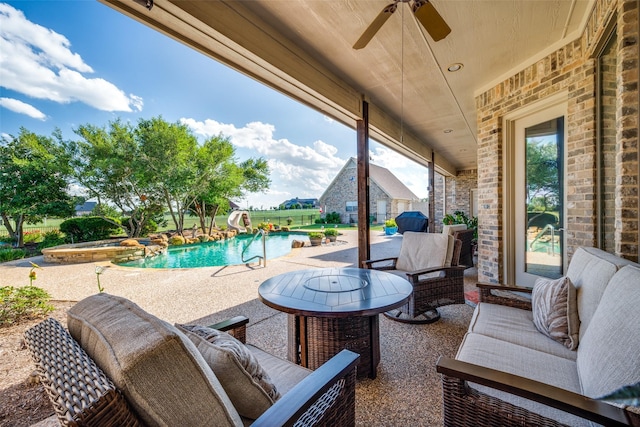 view of patio / terrace with a ceiling fan and a pool with connected hot tub