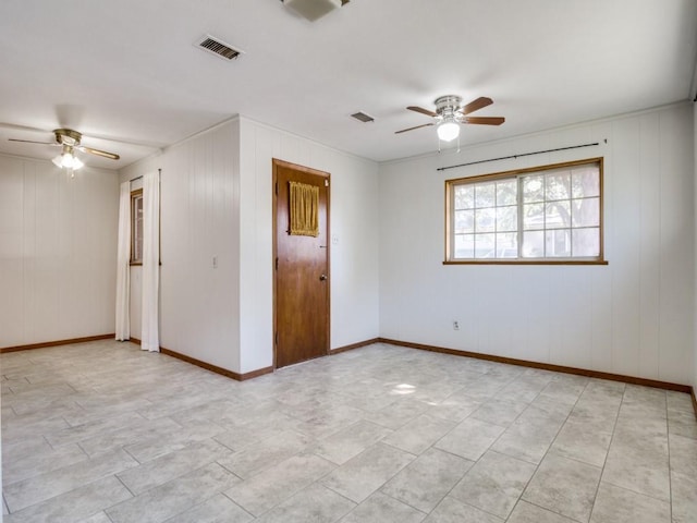 empty room featuring visible vents, ceiling fan, and baseboards