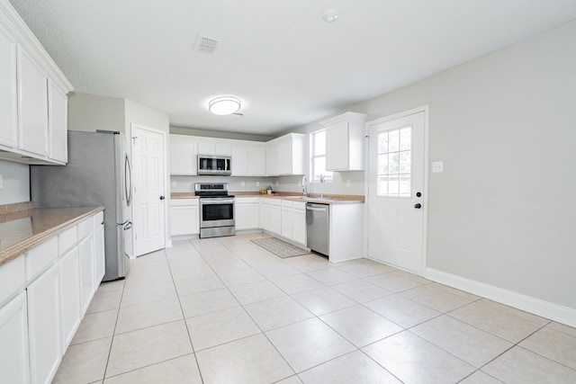 kitchen with stainless steel appliances, light countertops, visible vents, and light tile patterned flooring