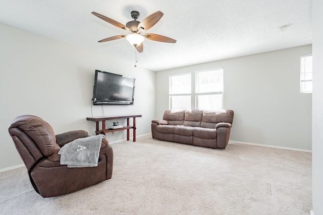 living area with baseboards, a textured ceiling, and carpet flooring