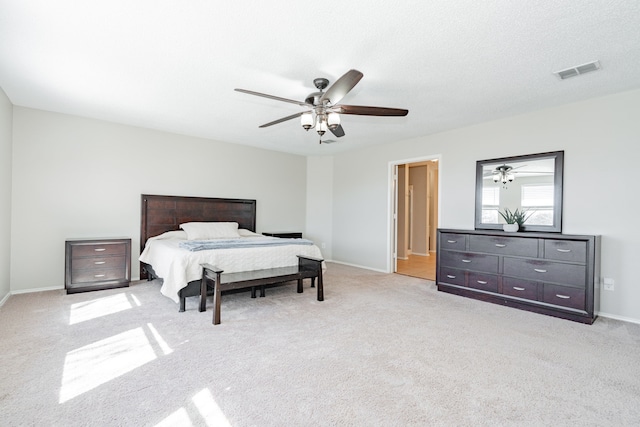 bedroom featuring light carpet, baseboards, visible vents, a ceiling fan, and a textured ceiling