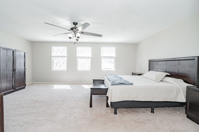 carpeted bedroom featuring ceiling fan, multiple windows, a textured ceiling, and baseboards