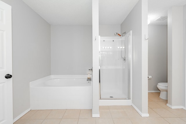 bathroom featuring toilet, a textured ceiling, a shower stall, tile patterned flooring, and a bath