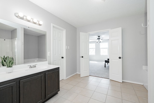 full bath featuring ceiling fan, baseboards, a tub, and tile patterned floors