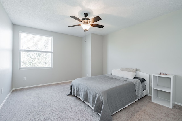 bedroom featuring a ceiling fan, carpet flooring, a textured ceiling, and baseboards