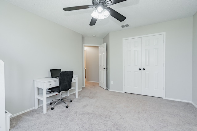 office featuring carpet floors, baseboards, visible vents, and ceiling fan