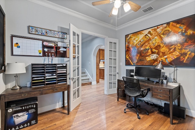 home office featuring visible vents, arched walkways, wood finished floors, crown molding, and french doors