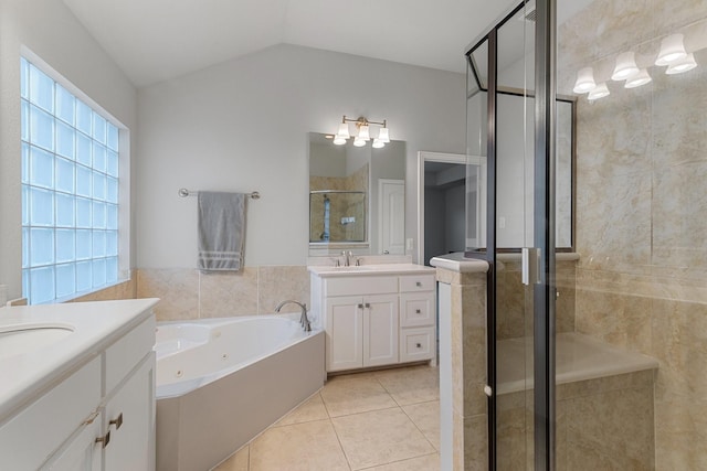 bathroom with a stall shower, lofted ceiling, tile patterned floors, a garden tub, and two vanities