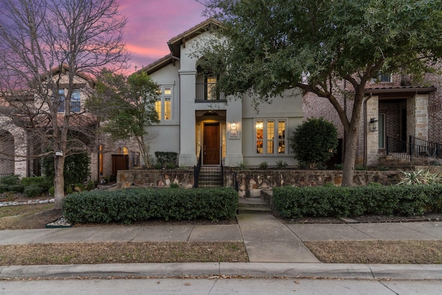 view of front of house with a tile roof and stucco siding