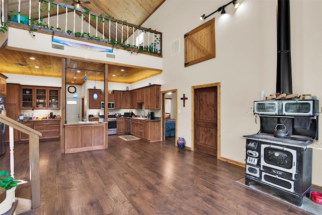 kitchen featuring a sink, wood ceiling, appliances with stainless steel finishes, brown cabinets, and dark wood finished floors