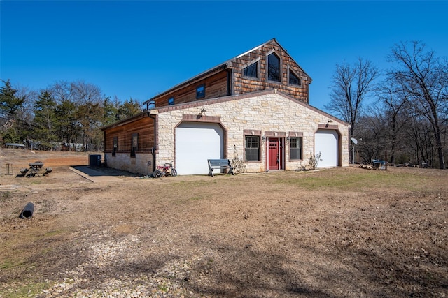 view of side of property with a garage and stone siding