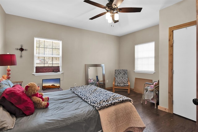 bedroom with dark wood-style floors, baseboards, and a ceiling fan