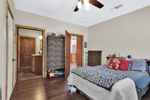 bedroom with a ceiling fan, wood finished floors, visible vents, and connected bathroom