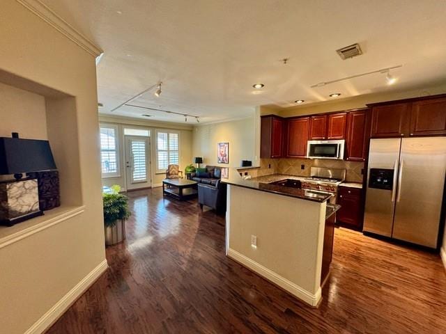 kitchen featuring stainless steel appliances, a peninsula, visible vents, open floor plan, and dark wood finished floors