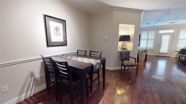 dining area with dark wood-style flooring, crown molding, and baseboards