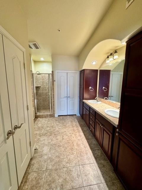 bathroom featuring a shower stall, visible vents, a sink, and tile patterned floors