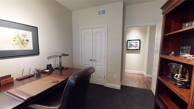 office space with baseboards, visible vents, and dark colored carpet