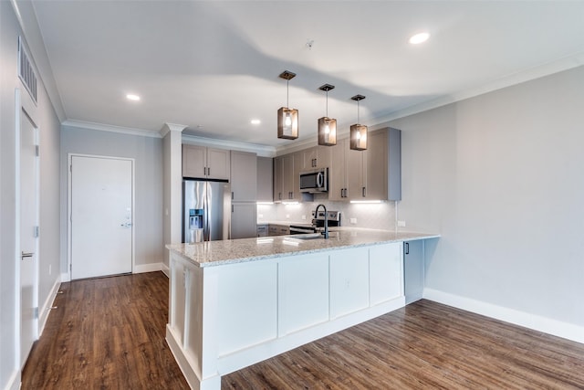 kitchen with a peninsula, a sink, appliances with stainless steel finishes, gray cabinets, and light stone countertops