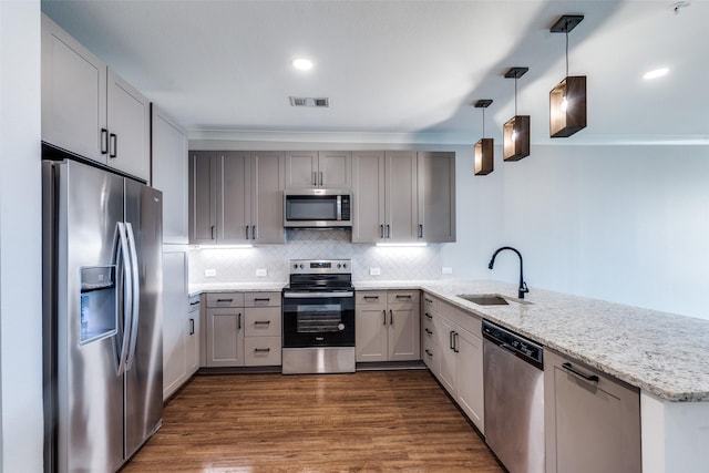 kitchen with visible vents, decorative backsplash, appliances with stainless steel finishes, a sink, and a peninsula