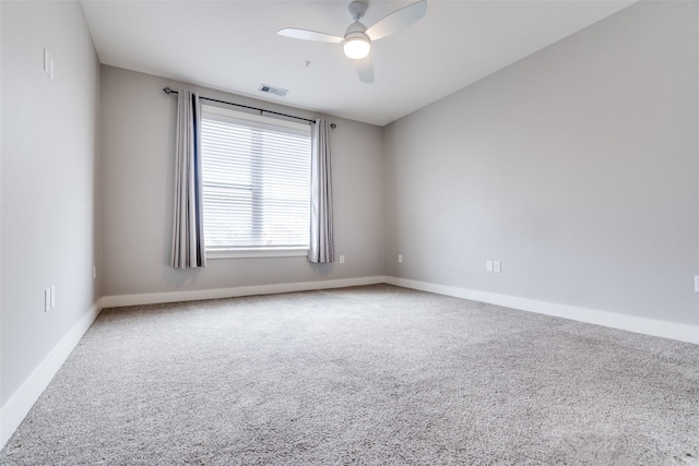 empty room featuring ceiling fan, carpet, visible vents, and baseboards