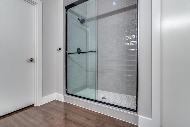 full bathroom with a shower stall and wood finished floors