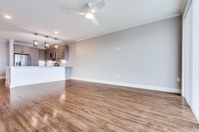 unfurnished living room with ornamental molding, baseboards, light wood finished floors, and a ceiling fan