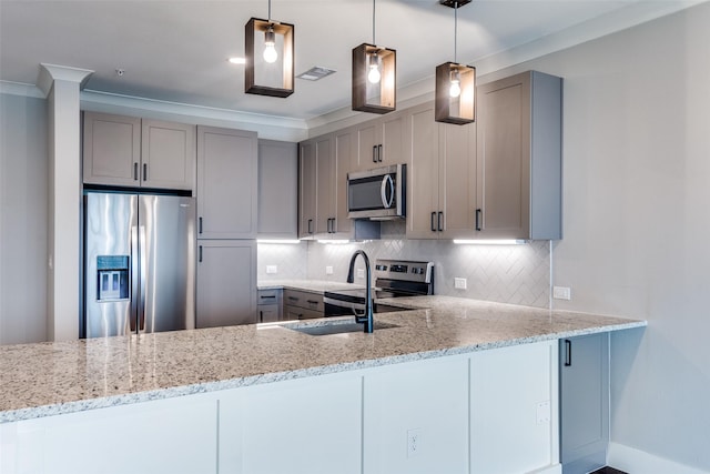 kitchen with appliances with stainless steel finishes, light stone counters, backsplash, and gray cabinetry