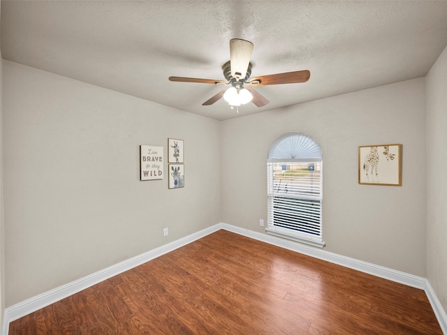 spare room with ceiling fan, a textured ceiling, wood finished floors, and baseboards