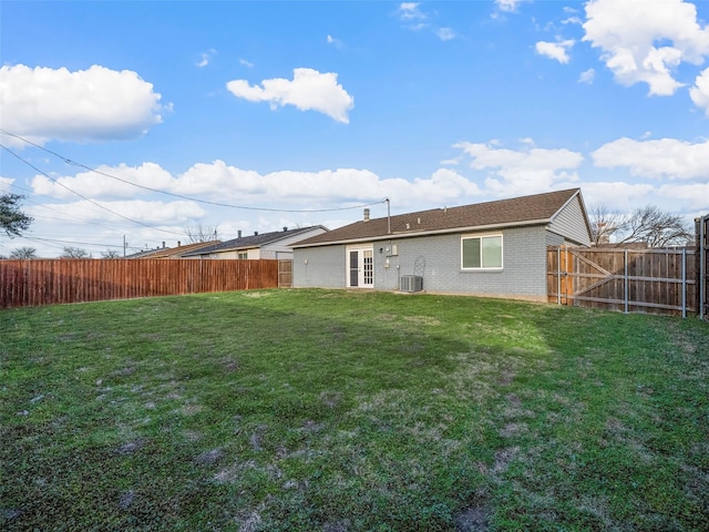 back of property with brick siding, a lawn, and a fenced backyard