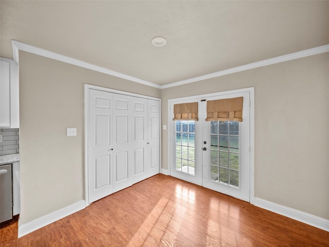 entryway featuring crown molding, french doors, baseboards, and light wood-style floors