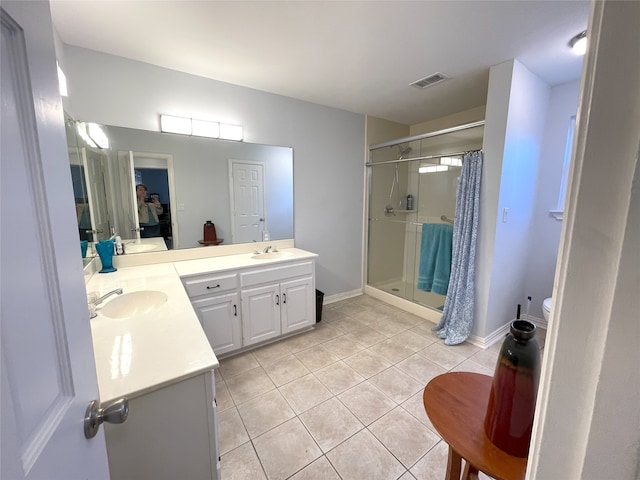 bathroom featuring tile patterned flooring, vanity, visible vents, baseboards, and a shower stall