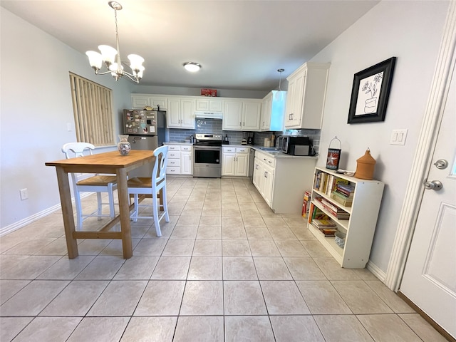 kitchen featuring decorative backsplash, appliances with stainless steel finishes, hanging light fixtures, white cabinetry, and light tile patterned flooring