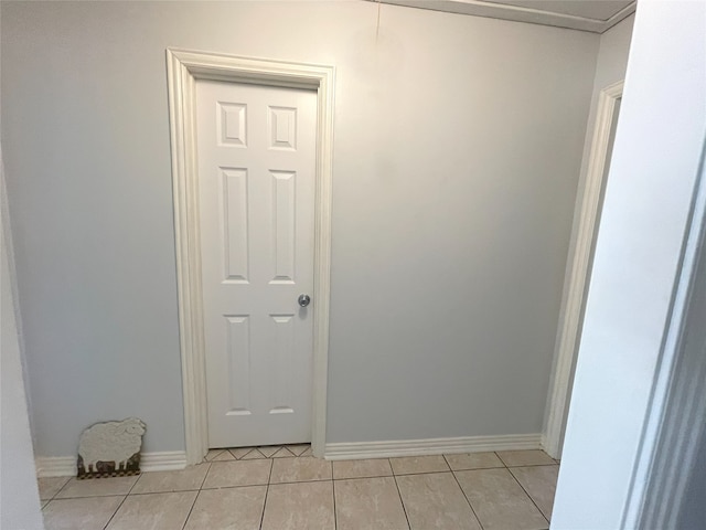 corridor featuring baseboards and light tile patterned floors