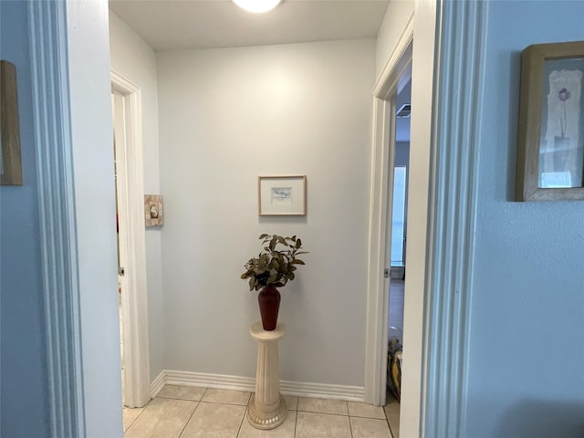 hallway featuring baseboards and light tile patterned floors